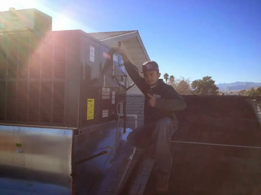 HVAC technician performing HVAC Inspection on a rooftop unit in Livingston